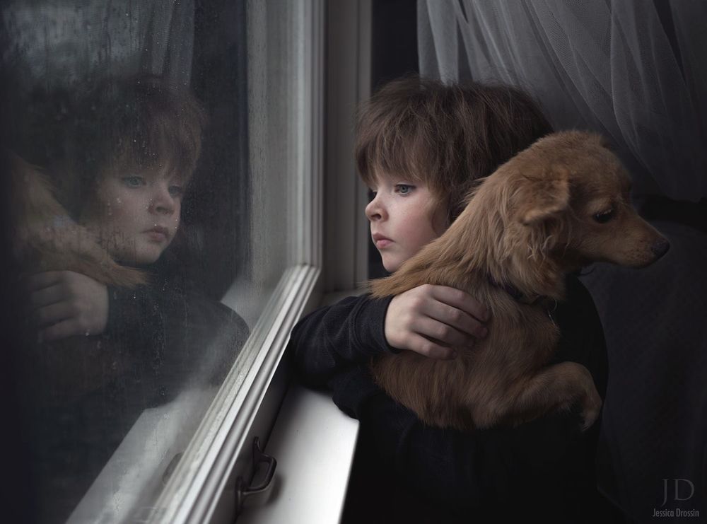 Обои для рабочего стола Маленький мальчик, держа на руках собаку очень грустно и волнительно в ожидании смотрит в окно за которым идет дождь, by Djessica Drossin