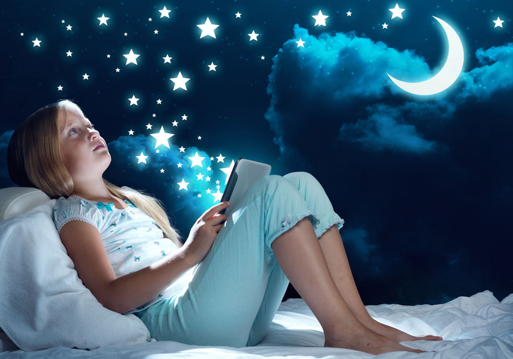 Обои для рабочего стола Девочка с книгой в руках на фоне ночного неба