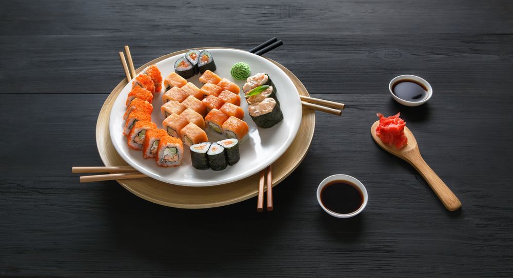 Обои для рабочего стола Японская кухня: роллы, маринованный имбирь, соус и васаби, рядом палочки для еды
