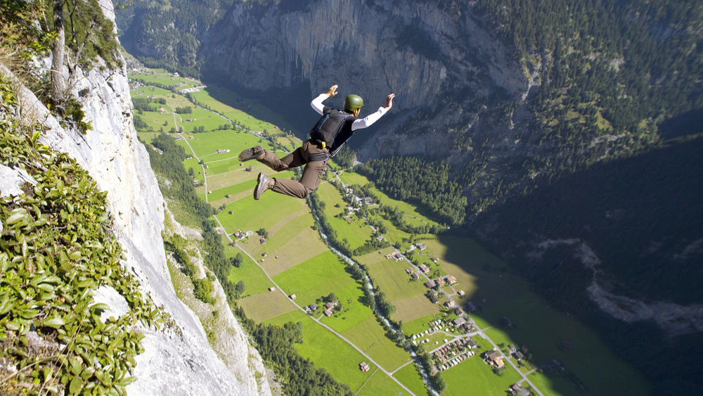 Обои для рабочего стола Мужчина прыгает с парашютом с горы