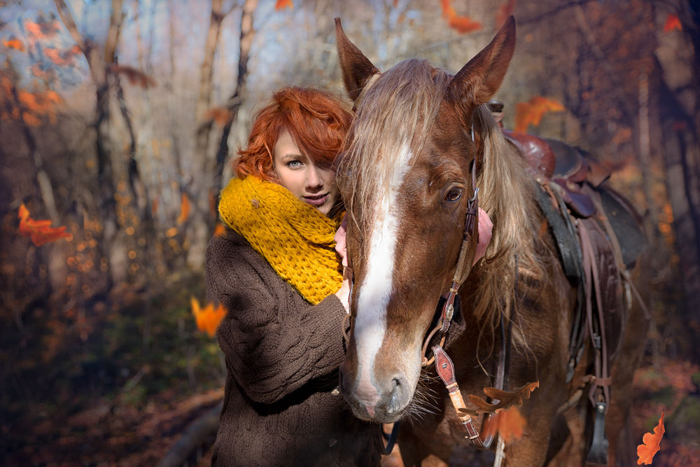 Обои для рабочего стола Рыжеволосая девушка стоит рядом с лошадью на размытом осеннем фоне. Фотограф Таня Маркова