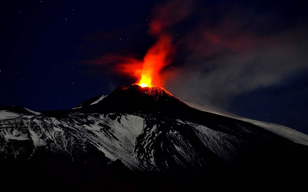 Обои для рабочего стола Огонь и клубы дыма вырывается из жерла действующего вулкана Etna, Italy / Этна, Италия на фоне ночного неба