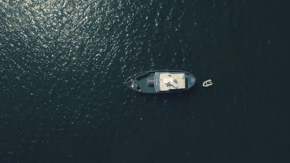 Обои для рабочего стола Вид сверху на лодку в открытой воде