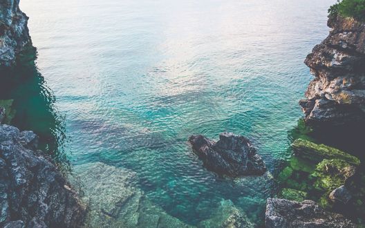 Обои на рабочий стол Бирюзовое море, открывающееся между скал