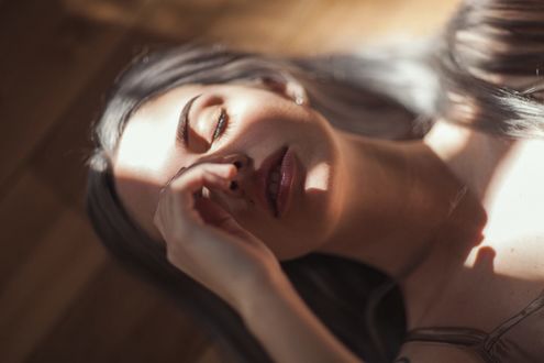 Обои на рабочий стол Девушка в солнечном свете лежит на полу, фотограф Ruby James