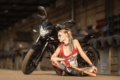 Обои на рабочий стол Девушка в образе Harley Quinn / Харли Квинн сидит у мотоцикла
