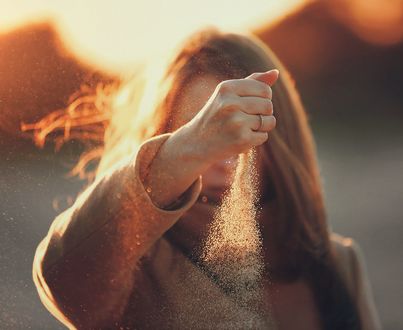 Обои на рабочий стол Девушка высыпает песок из руки, фотограф Luis Valadares