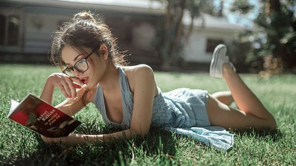 Обои на рабочий стол Девушка с книгой лежит на траве, фотограф Георгий Чернядьев