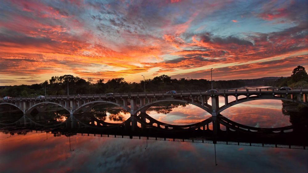 Обои для рабочего стола Мост через реку на фоне красивого закатного неба, отражение