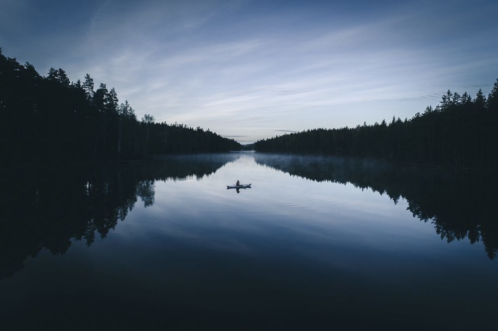 Обои для рабочего стола Рыбак в лодке на воде, фотограф Tobias HГ¤gg