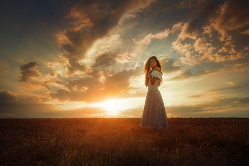 Обои на рабочий стол Девушка стоит в поле на фоне заката, фотограф TJ Drysdale