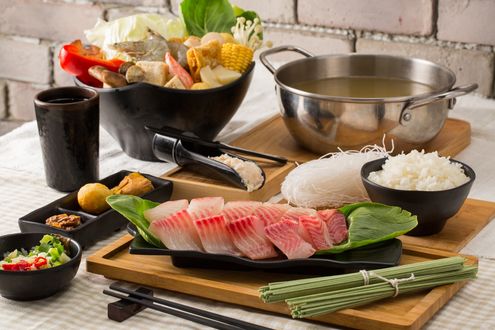 Обои на рабочий стол Японская кухня: Рыба, рос, лапша, ассорти из овощей, рядом кастрюля с бульоном и палочки для еды