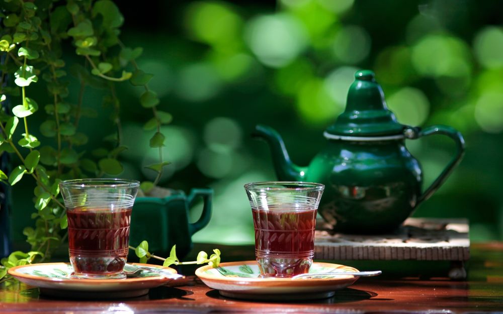 Обои для рабочего стола Две чашки чая и зеленый чайник на столике на природе