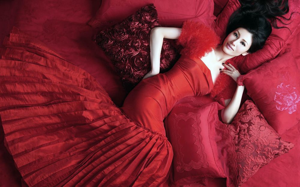 Обои для рабочего стола Азиатка в красном платье лежит на красной постели, модель Michelle Monique Reis Lee