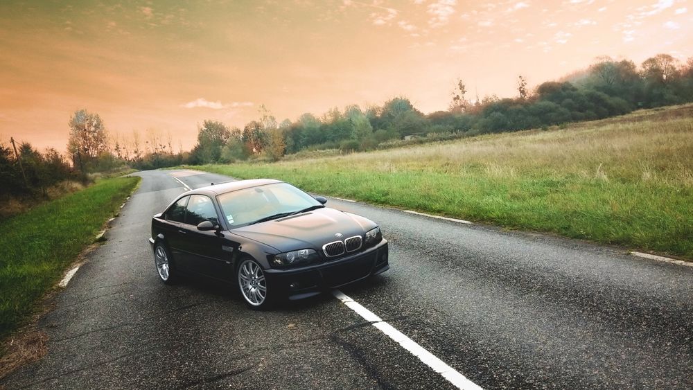 Обои для рабочего стола Черный BMW стоит на дороге