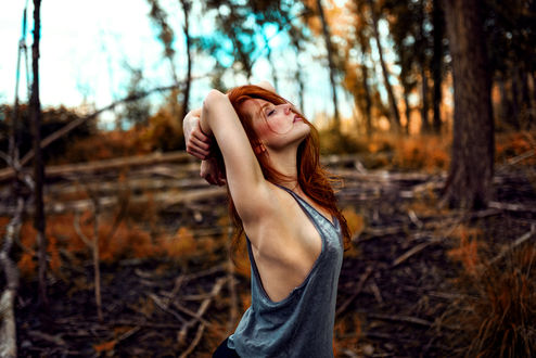 Обои на рабочий стол Рыжеволосая девушка стоит на фоне леса, фотограф Miro Hofmann