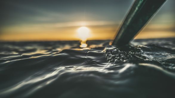 Обои на рабочий стол Весло в море на закате солнца, крупный план