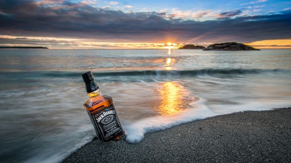 Обои на рабочий стол Бутылка виски Jack Daniel’s / Джек Дэниелс на берегу моря