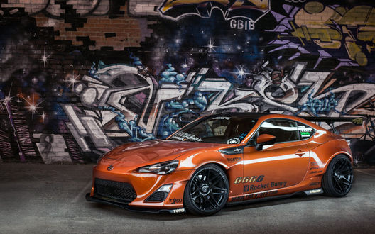 Обои на рабочий стол Nissan GT-R стоит на фоне стены с граффити