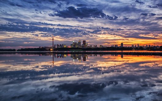 Обои на рабочий стол В реке отражается облачное небо над городом