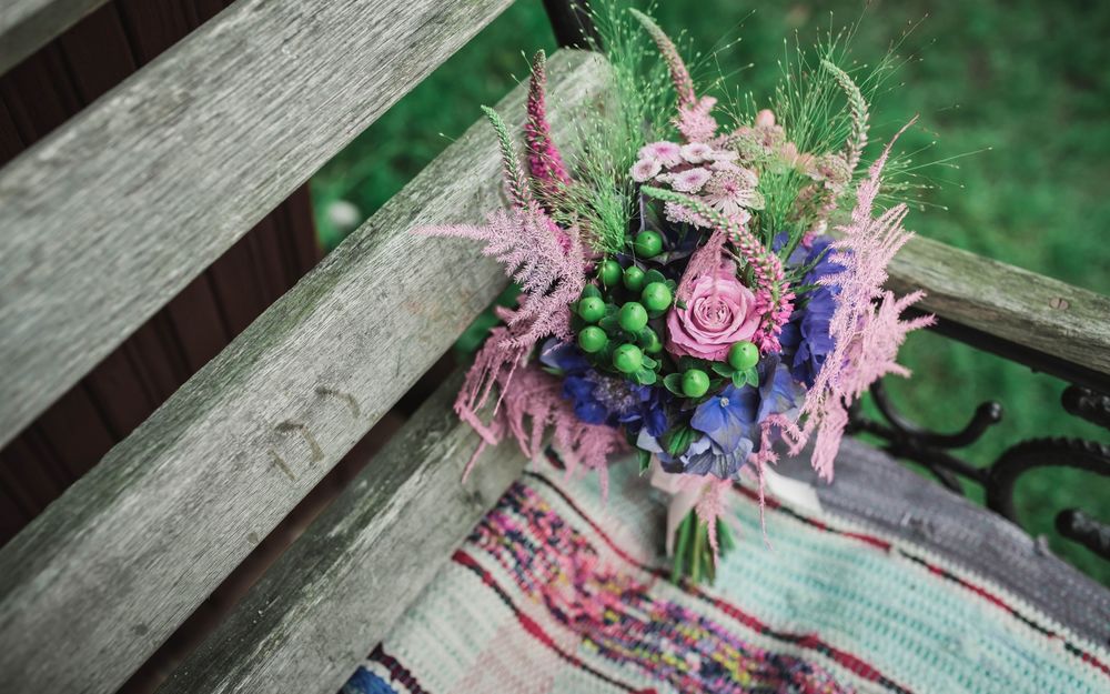 Обои для рабочего стола Букет летних цветов стоит на садовой скамейке