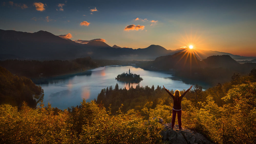 Обои для рабочего стола Девушка встречает рассвет на озере Bled, Slovenia / Блед, Словения, фотограф rasica-Radisa Zivkovic