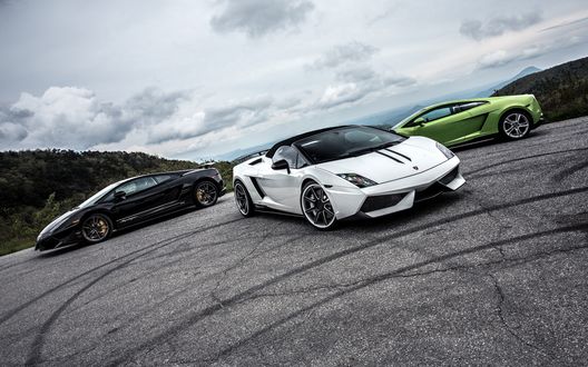 Обои на рабочий стол Три машины марки Lamborghini на дороге
