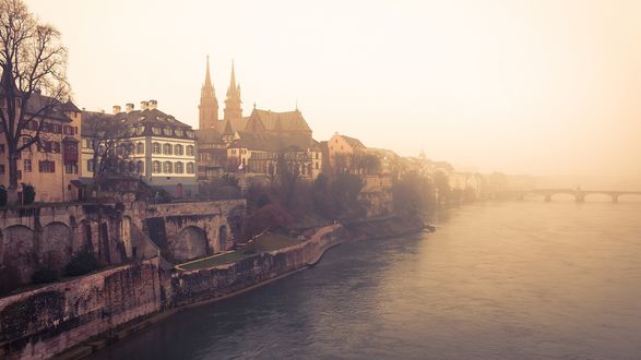 Обои на рабочий стол Здания на побережье города Базель / Basel со шпилями в тумане возле реки с мостом, Швейцария / Switzerland