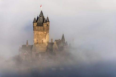 Обои на рабочий стол Древний замок Рейхсбург Кохем / Reichsburg Cochem Германия / Germany с флагом на вершине в тумане