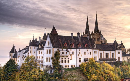 Обои на рабочий стол Белый старинный замок Neuchatel, Switzerland / Невшатель, Швейцария осенью на горе среди деревьев с желтыми листьями под ванильным небом