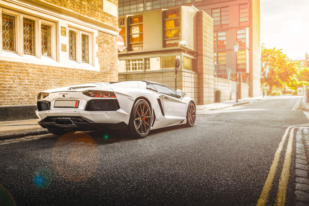 Обои для рабочего стола Белый Lamborghini стоит на дороге в городе