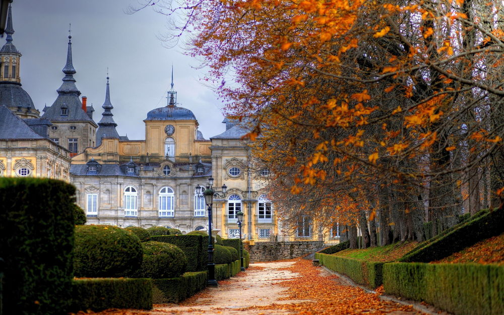 Обои для рабочего стола Royal Palace of La Granja de San Ildefonso, Spain / королевский дворец Ла Гранха-де-Сан-Ильдефонсо, в Испании и сад с подстриженными кустами осенью. Деревья с опавшими осенними листьями на дорожке