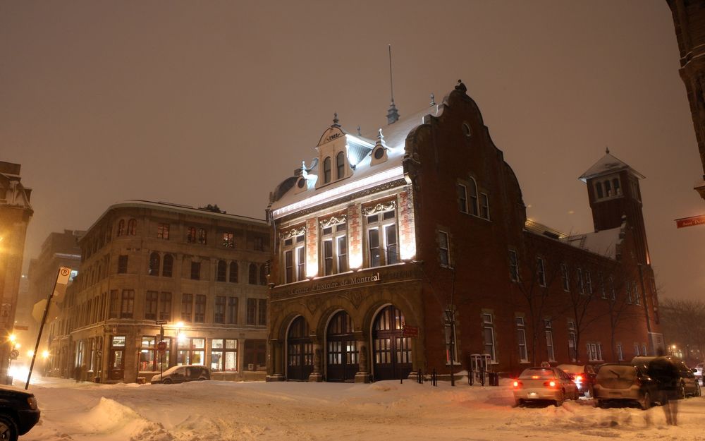 Обои для рабочего стола Кирпичное здание на пересечении улиц зимой вечером в городе в Европе