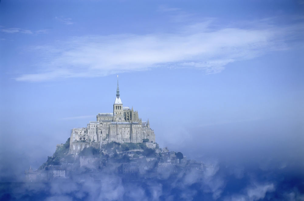 Обои для рабочего стола Замок Мон-сан Мишель Франция в голубом тумане и облаках