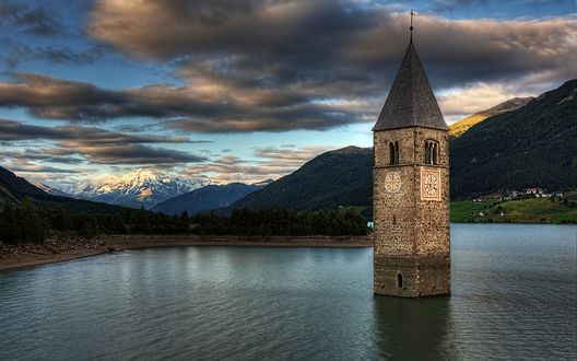 Обои на рабочий стол Старинная часовня посреди озера Реция, Италия / Rezia, Italy на фоне гор и неба с перистыми облаками, подсвеченными заходящим солнцем