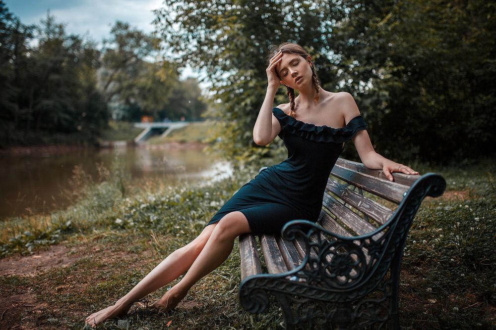 Обои для рабочего стола Модель Disha Shemetova / Даша Шеметова в черном платье сидит на лавочке у реки