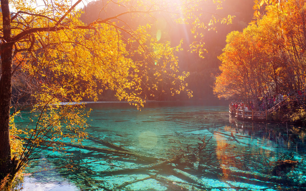 Обои для рабочего стола Прозрачное голубое озеро, в котором отражаются яркие осенние деревья и поднимается легкий туман