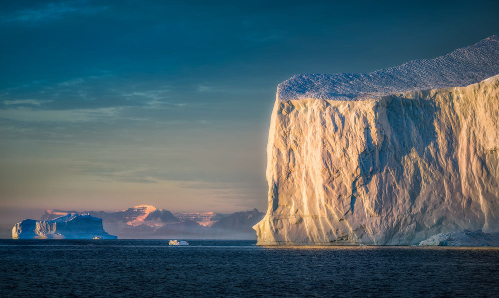 Обои для рабочего стола Гигантский айсберг ранним утром в Eastern Greenland / Восточной Гренландии, фотограф Hans-Peter Deutsch