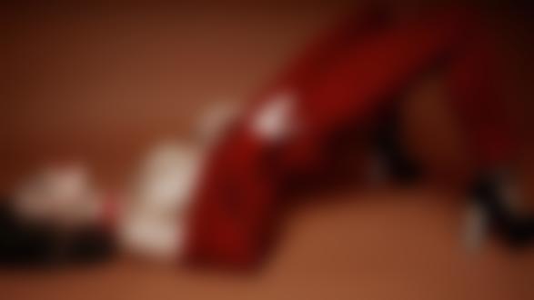 Обои на рабочий стол Симпатичная брюнетка в расстегнутой одежде с обнаженной грудью позирует лежа на размытом фоне