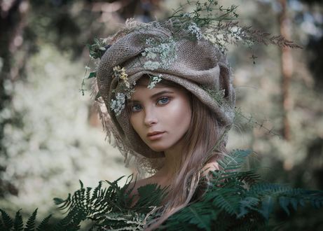 Обои на рабочий стол Модель Алла стоит за листвой с цветами на головном уборе, фотограф Ilya Varivchenko