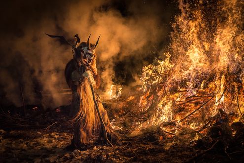 Обои на рабочий стол Демон с открытой пастью стоит у костра, Italy, Feast of San Nicholas and Krampus / Италия, праздник Сан Николо и Крампусы, фотограф Stefano Sudaro