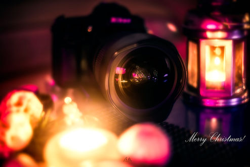 Обои на рабочий стол В объективе фотоаппарата отражается елка и горящие свечи, рядом фонарь, (Merry Christmas! / Счастливого Рождества!), by Croosterpix
