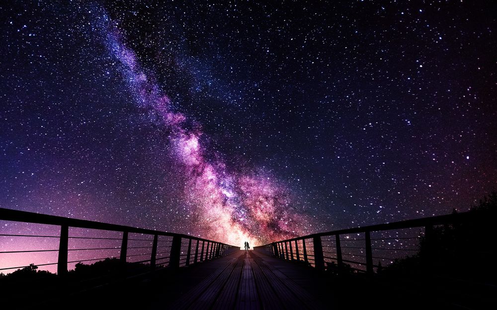 Обои для рабочего стола Силуэт пары на мосту, на фоне сияния в звездном небе, фотограф Sebastien Gaborit