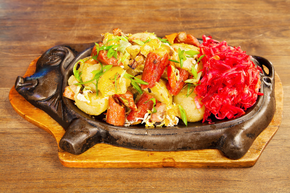 Обои для рабочего стола Мясо с овощами на деревянном блюде в форме поросенка на столе