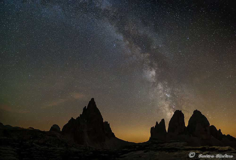 Обои для рабочего стола Tre Cime di Lavaredo / Тре-Чиме-ди-Лаваредо - горный массив в Itali / Италии под ночным небом, фотограф Stefano Sudaro