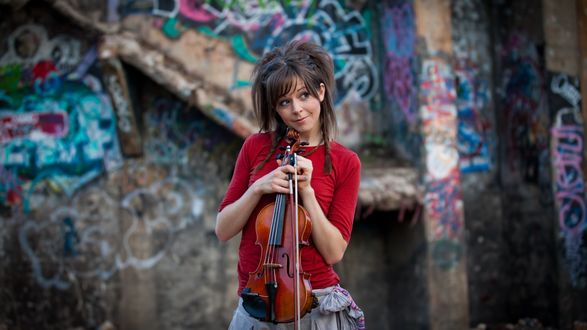 Обои на рабочий стол Известная скрипачка Линдси Стирлинг / Lindsey Stirling позирует со скрипкой в руках, на фоне разрисованной граффити стены