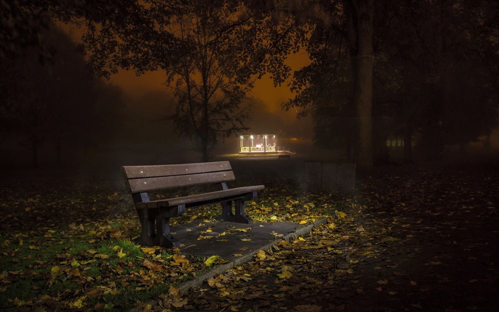 Обои для рабочего стола Одинокая скамейка, освещенная фонарями в ночном осеннем парке