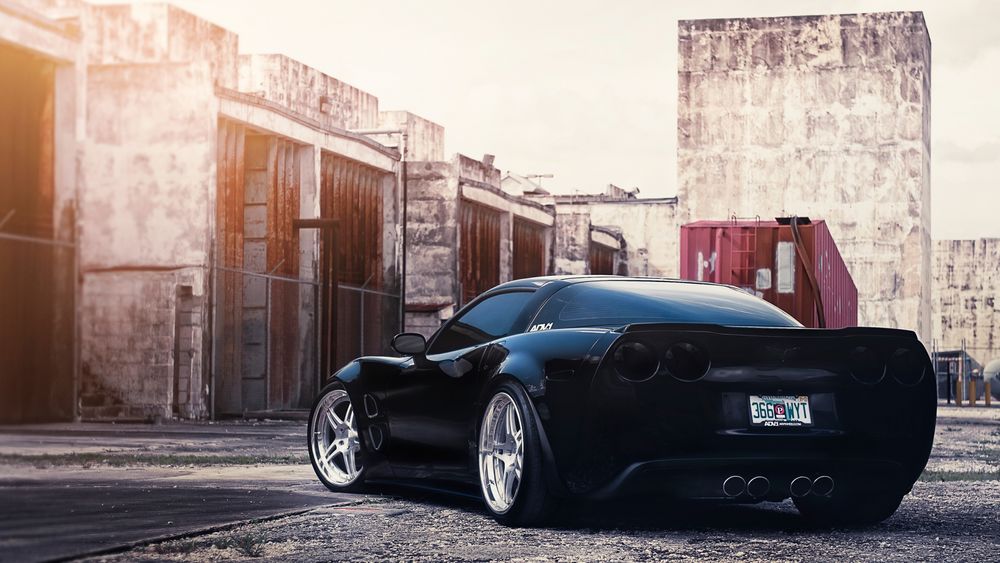 Обои для рабочего стола Chevrolet corvette возле старого здания