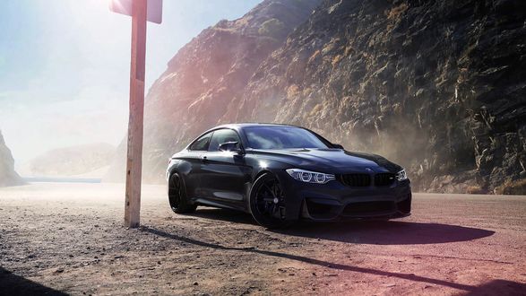 Обои на рабочий стол Черный BMW M4 на прибрежной дороге