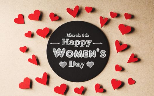 Обои на рабочий стол Сердечки лежат вокруг черной дощечки с фразой 8 March, Happy Womans Day / 8 марта, Международный женский день на ней